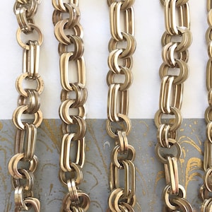 Puede incluir: Cinco hebras de collar de cadena de oro con un diseño delicado e intrincado. Cada hebra está hecha de múltiples eslabones pequeños de forma ovalada que se entrelazan para crear un look único y elegante.