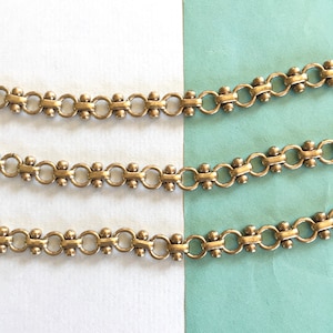 May include: Three rows of silver chain with small round beads. The chain is made of interlocking circles with a bead in the center of each circle.