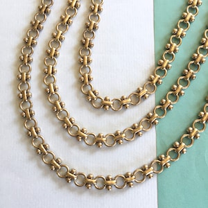 May include: Three gold chains with a linked pattern. Each chain has a different length.