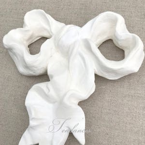 Large antique bow decoration in plasterwork