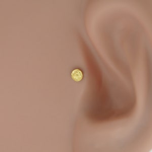 Gold tragus and helix earring featuring a moon surface, crafted from bioflex. Lightweight and flexible, it’s perfect for individuals with sensitive skin.
