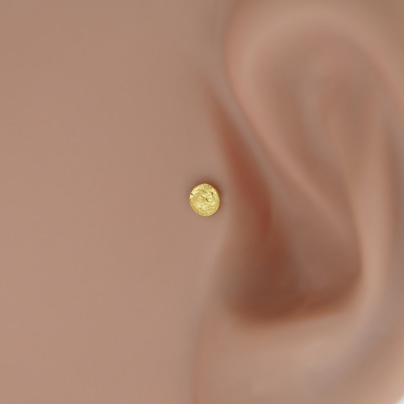 Gold tragus and helix earring featuring a moon surface, crafted from bioflex. Lightweight and flexible, it’s perfect for individuals with sensitive skin.