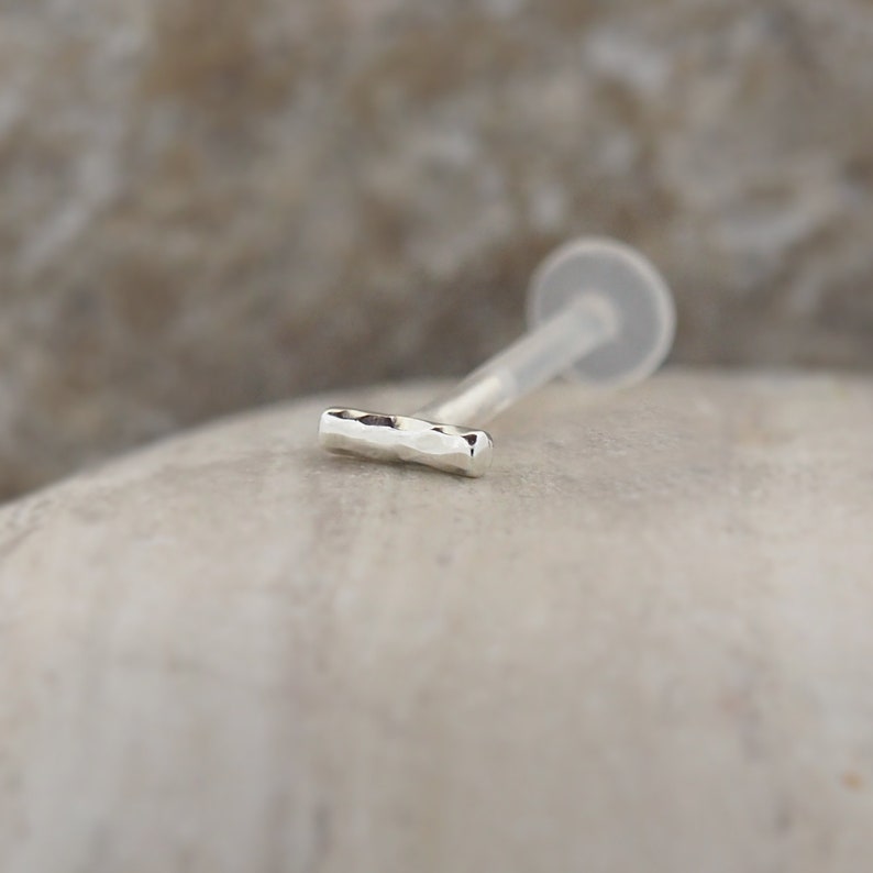 Minimalist tragus and helix earring in classic silver, made from bioflex. Its sleek design offers a stylish option for layering with other ear jewelry.