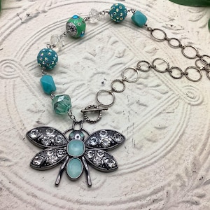 Handgemachte asymmetrische Halskette mit blauen Schmetterling und Glasperlen