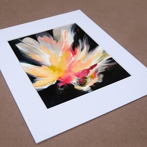 K&ouml;nnte beinhalten: Abstrakte Malerei einer Blume mit gelben, rosa und wei&szlig;en Bl&uuml;tenbl&auml;ttern auf schwarzem Hintergrund. Das Gem&auml;lde ist mit einem wei&szlig;en Passepartout gerahmt.