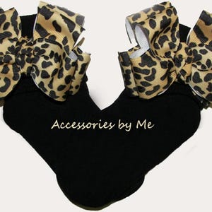 May include: Black socks with a large leopard print bow on each side. The socks have the text "Accessories by Me" printed on the bottom.