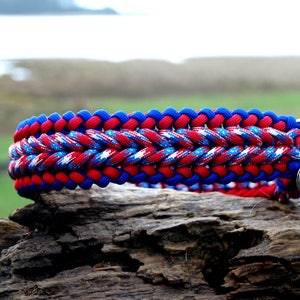 May include: A red, white, and blue paracord dog collar with a silver D-ring and paw charm.