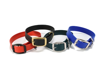 May include: Four collars in red, black, dark green, and blue. Each collar features a smooth, solid-coloured strap with a metal buckle and a D-ring. The red collar has a black buckle, the black collar has a gold buckle, and the green and blue collars have silver-toned buckles.