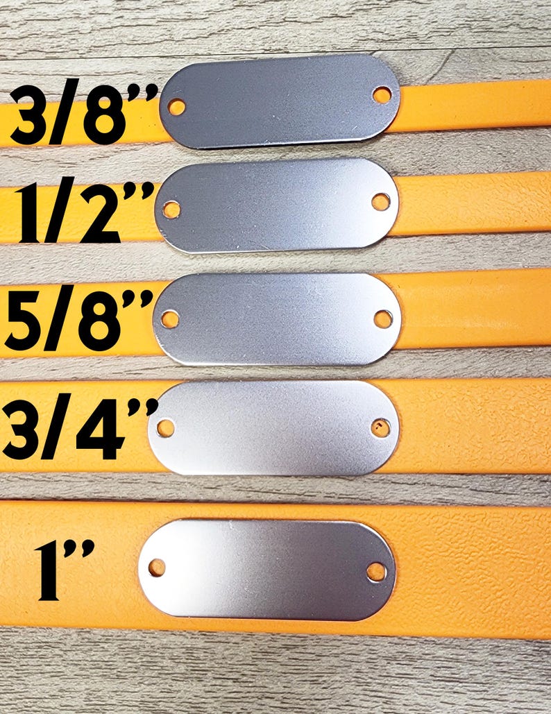 May include: Five silver oval-shaped metal tags with holes on either side, attached to orange leather straps. The tags are labelled with the following sizes: 3/8", 1/2", 5/8", 3/4", and 1".