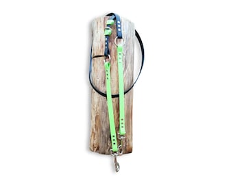 May include: A multi-functional dog leash featuring a combination of black and neon green straps. The leash includes silver-toned metal hardware, including circular rings and swivel snap hooks, with adjustable sections secured by metal rivets.