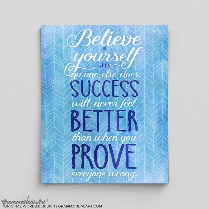 May include: A motivational art print with a blue watercolor background and white chevron pattern. The text reads "Believe in yourself when no one else does; SUCCESS will never feel BETTER than when you PROVE everyone wrong." The bottom left corner has the text "Grammatical Art".