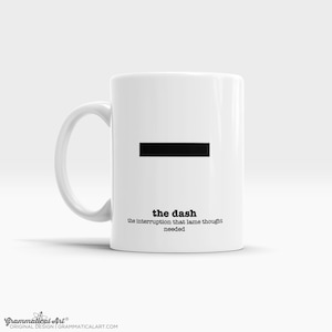 Può includere: Una tazza in ceramica bianca con un trattino nero e il testo "the dash the interruption that lame thought needed".