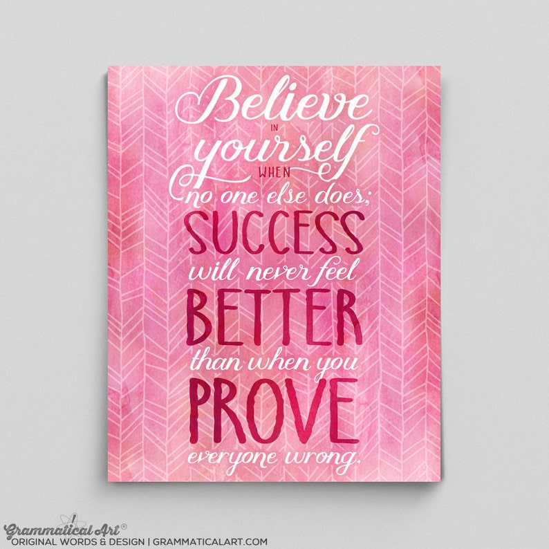 May include: A pink and white inspirational art print with the words "Believe in yourself when no one else does; SUCCESS will never feel BETTER than when you PROVE everyone wrong." The background has a chevron pattern.