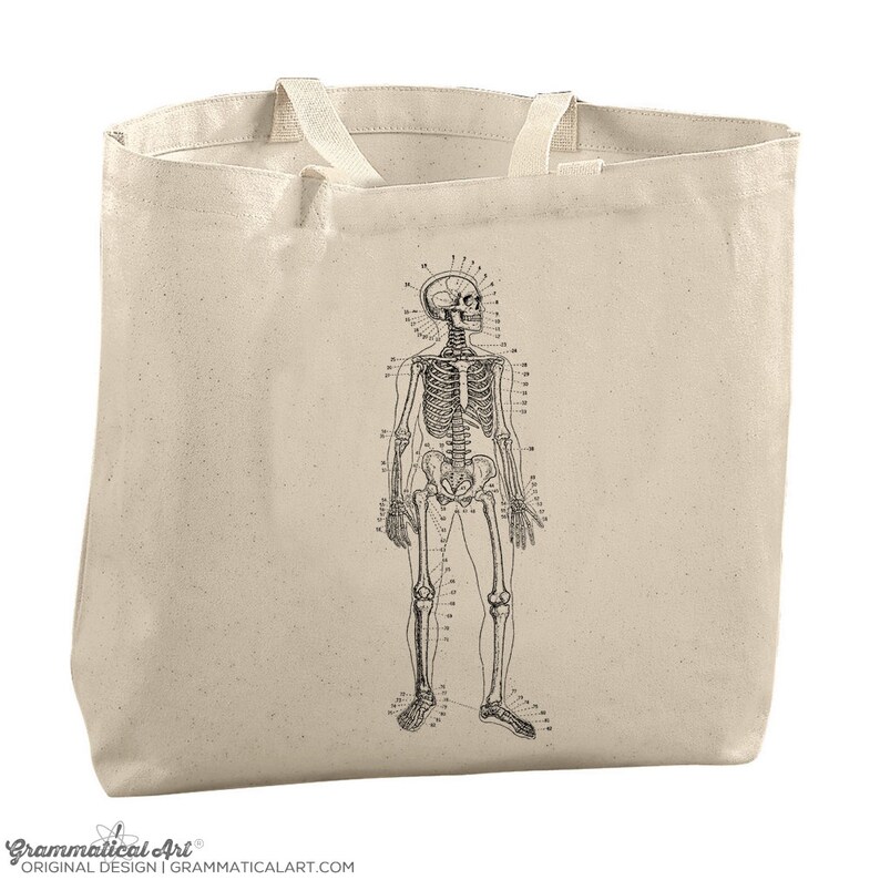 May include: A beige tote bag with a black and white anatomical illustration of a human skeleton on the front.