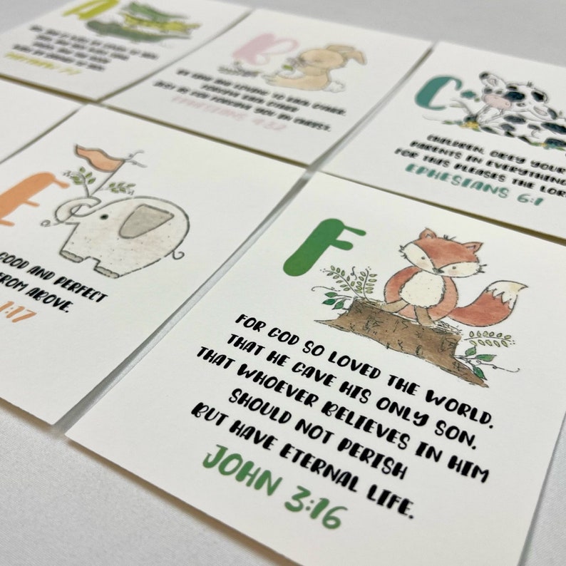 Op de afbeelding: Een set alfabetkaarten met kleurrijke letters en illustraties van dieren. Elke kaart bevat een Bijbelvers. De kaarten zijn perfect om kinderen het alfabet en de Bijbel te leren.