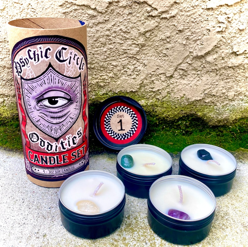 Pode incluir: Conjunto de quatro pequenas velas de soja em latas pretas com um cristal embutido em cada uma. As velas s&atilde;o etiquetadas como "Psychic Circle Oddities Candle Set" e "4 - 3 oz Soy Candles".