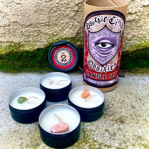 Pu&ograve; includere: Set di quattro piccole candele in barattoli neri con un singolo cristallo incorporato in ciascuno. Le candele sono etichettate "Psychic Circle Oddities Candle Set" e "1 - 3oz Soy Candles".