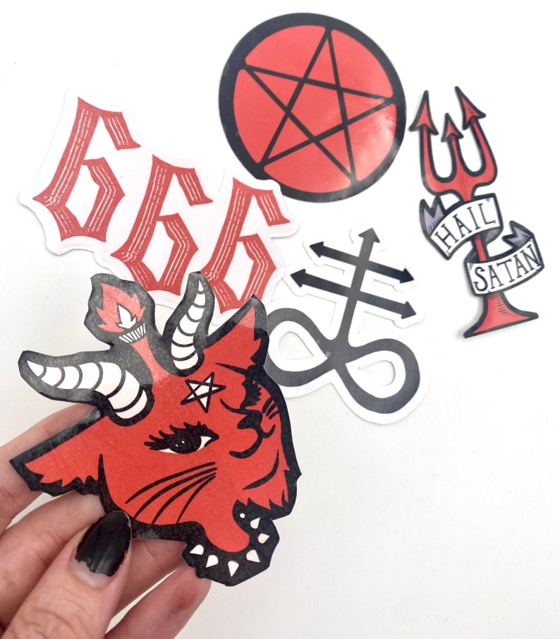 May include: Five red and black stickers with a satanic theme. The stickers include a pentagram, a goat head, a trident, the number 666, and a symbol with a cross and an infinity sign. The trident sticker has the words "Hail Satan" on a banner.