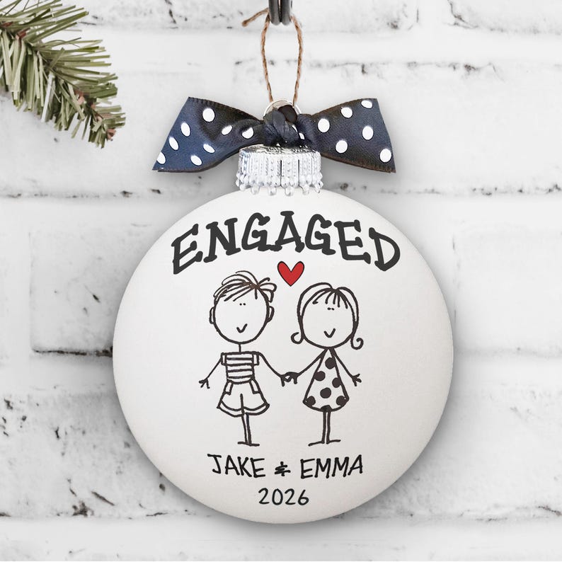 Whimsical engaged couple artwork with "Engaged" written above couple and first names and 2026 below.
