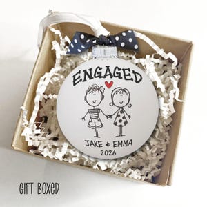Personalized Engagement Ornament - White glass ball ornament, hand painted with whimsical couple holding hands with ENGAGED above them and names and year below. Little red heart and polka dot bow. Engaged Couple Gift Custom Names Date, Keepsake Bridal Shower Present