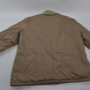 May include: A brown quilted jacket with a ribbed collar and cuffs.