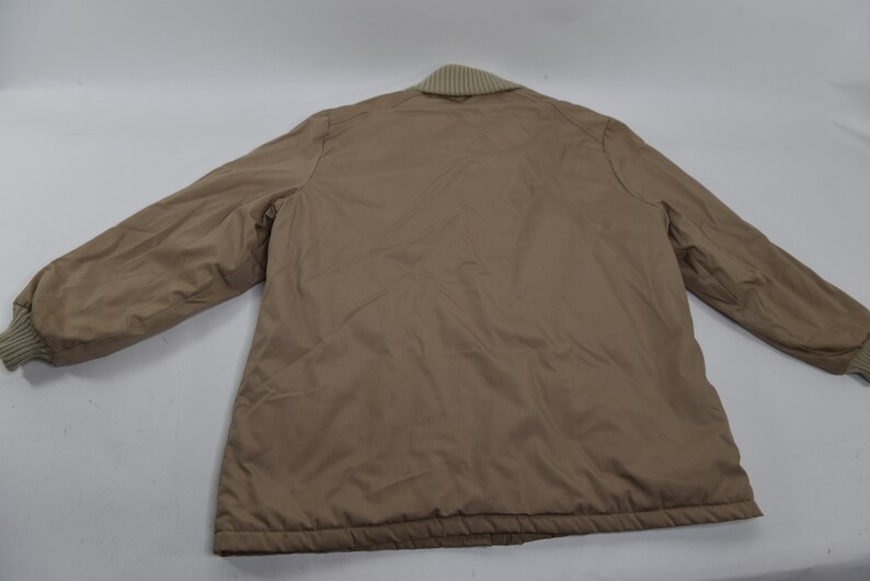 May include: A brown quilted jacket with a ribbed collar and cuffs.