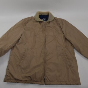 May include: A tan zip-up jacket with a brown knit collar and cuffs. The jacket has two pockets on the front and a zipper closure.