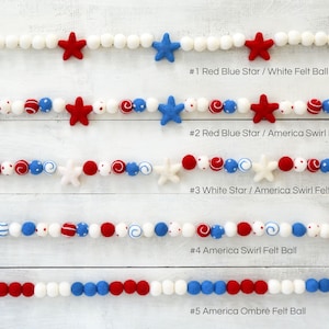 May include: Five different styles of felt ball garlands, each with a different pattern. The garlands are made with red, white, and blue felt balls and feature stars and swirls. #1 Red Blue Star / White Felt Ball, #2 Red Blue Star / America Swirl Felt Ball, #3 White Star / America Swirl Felt Ball, #4 America Swirl Felt Ball, #5 America Ombr&eacute; Felt Ball.