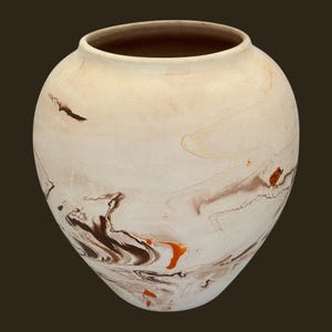 May include: A ceramic vase with a rounded body and a wide opening. The vase has a cream-coloured base with swirling patterns of brown, black, and orange. The interior is a darker brown. Suitable for home decor, this piece is a decorative item.