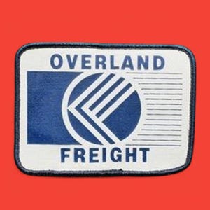 May include: A white patch with a blue and white logo and the text "OVERLAND FREIGHT".