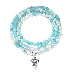 May include: A multi-strand bracelet made of blue and green gemstone beads with a silver turtle charm.