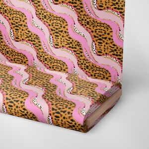 May include: A pink and brown fabric with a leopard print and wavy lines. The fabric is rolled up and the end is visible.