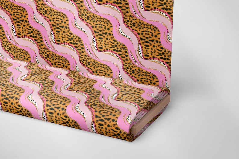 May include: A pink and brown fabric with a leopard print and wavy lines. The fabric is rolled up and the end is visible.