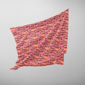 Op de afbeelding: Roze stof met een herhalend patroon van oranje pompoenen en het woord "Thankful" in zwarte cursieve letters.
