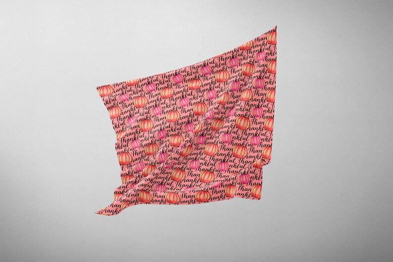 Op de afbeelding: Roze stof met een herhalend patroon van oranje pompoenen en het woord "Thankful" in zwarte cursieve letters.