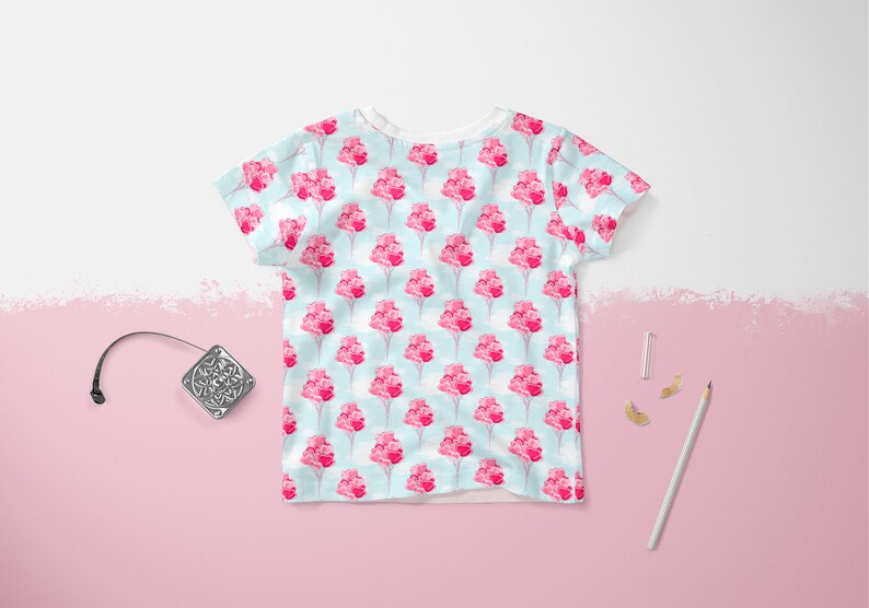 May include: A white t-shirt with a light blue background and a repeating pattern of pink flower bouquets.