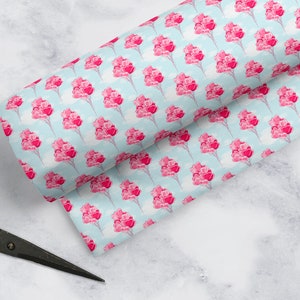 May include: A blue and white fabric with a repeating pattern of pink heart-shaped balloons. The balloons are tied together with strings and are floating in the air.
