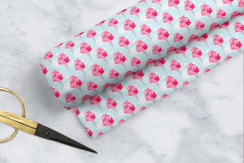 May include: A blue and white fabric with a repeating pattern of pink heart-shaped balloons. The balloons are tied together with strings and are floating in the air.