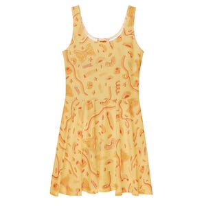May include: A yellow sleeveless dress with a scoop neck and a flared skirt. The dress is covered in a repeating pattern of orange pasta shapes, including bow ties, spirals, and tubes. The overall design is playful and food-themed.