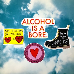 May include: Four colourful stickers with messages about alcohol and sobriety. The first sticker is yellow with red hearts and says "Not getting drunk is cool & valid". The second sticker is white with red and yellow text and says "Alcohol is a bore". The third sticker is pink with a red heart and says "Respect your sobriety friends support them". The fourth sticker is black with yellow text and says "Being sober is punk AF".