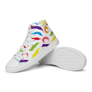 Puede incluir: Zapatillas blancas de lona de caña alta con un patrón de gusanos coloridos. Las zapatillas tienen cordones blancos y una suela blanca.