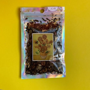 May include: A clear, iridescent sealed bag containing dried herbs and a small rectangular image of Van Gogh's "Sunflowers" painting. The bag is labeled with the text ".5 oz" at the top. The background is a solid yellow.