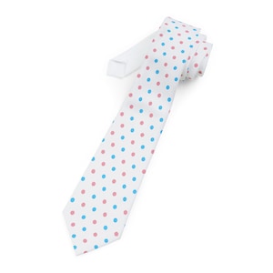 May include: A white necktie with a repeating pattern of pink and blue polka dots. The tie is made of a smooth fabric and is angled diagonally across the frame, showcasing its design. The tie is a classic accessory.