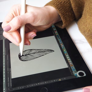 May include: A person using a white stylus to draw a black and white feather on a digital tablet.