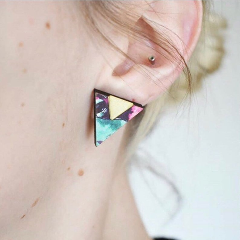 blonde woman wear's blue and gold triangle stud earrings on ear