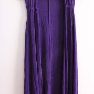 Puede incluir: Un c&aacute;rdigan morado sin mangas con un dise&ntilde;o largo y fluido. El c&aacute;rdigan tiene un estilo simple y elegante y est&aacute; hecho de una tela suave y c&oacute;moda.