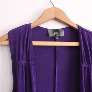 Puede incluir: Un c&aacute;rdigan morado sin mangas con una