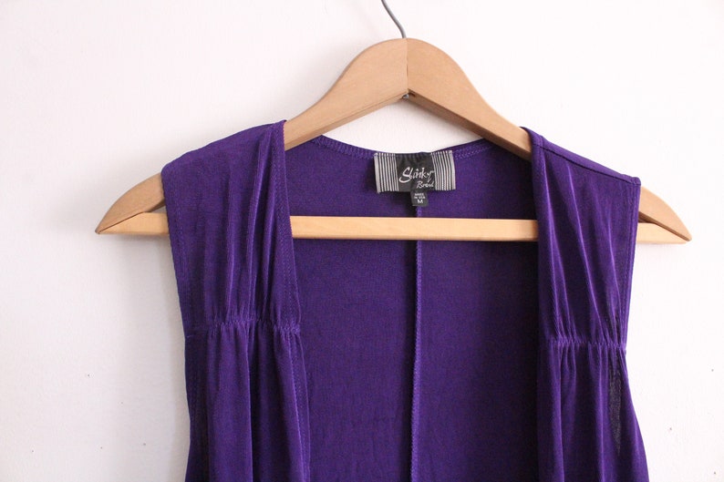 Puede incluir: Un c&aacute;rdigan morado sin mangas con una