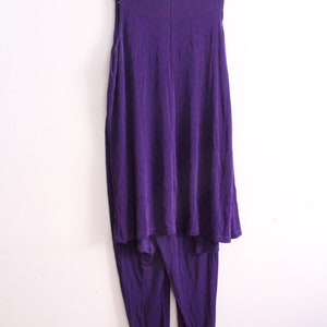 Puede incluir: Un mono morado sin mangas con una parte superior fluida y pantalones ajustados.