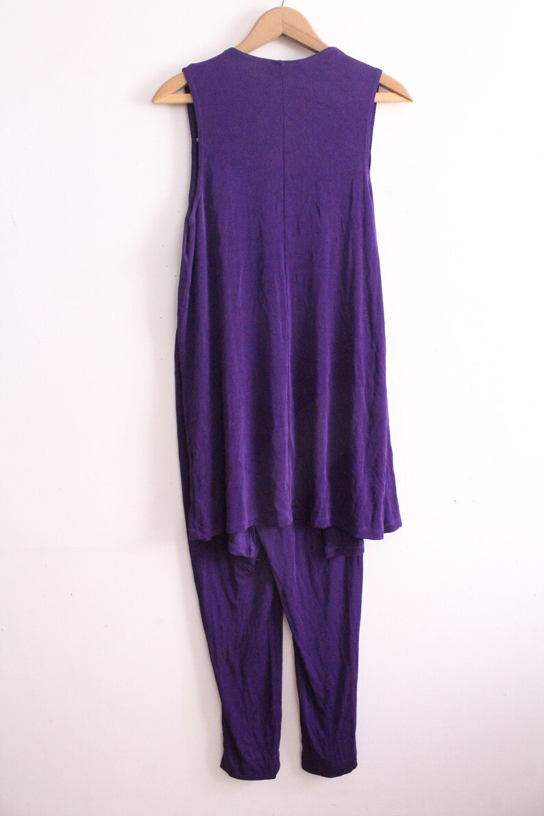 Puede incluir: Un mono morado sin mangas con una parte superior fluida y pantalones ajustados.